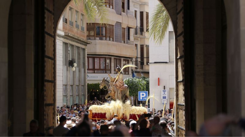 Varias personas portan el paso de la Borriquita adornado con palmas blancas durante la Procesión de Las Palmas en Elche | EP