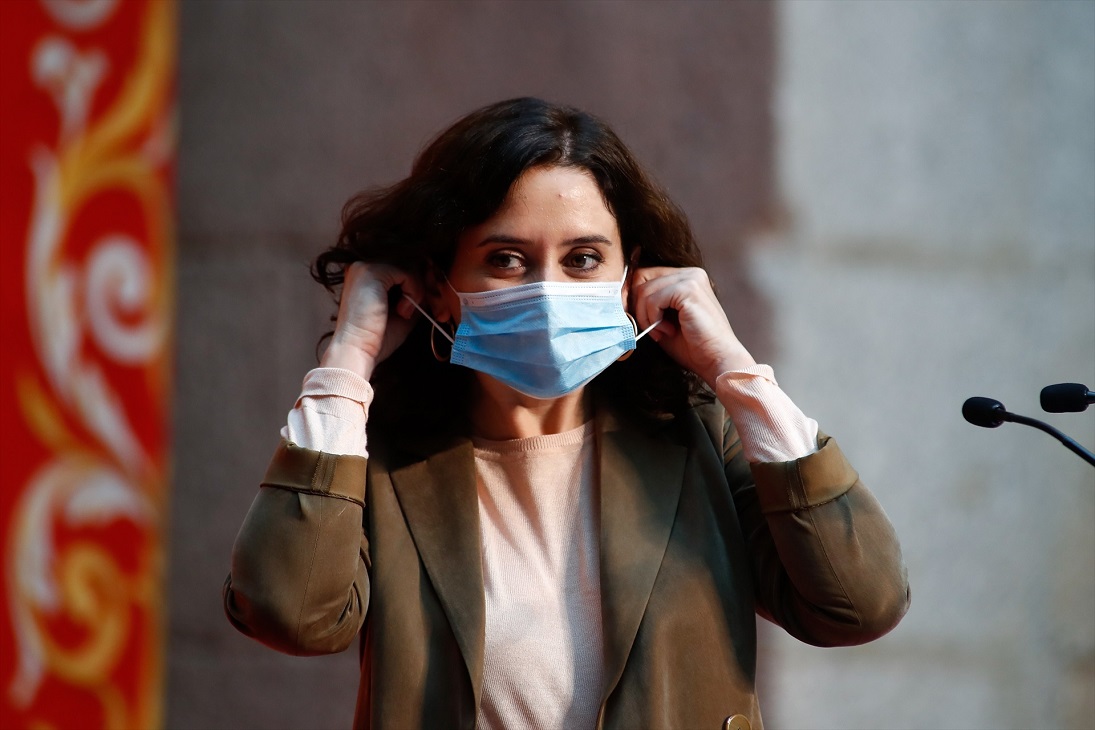 Isabel Díaz Ayuso se coloca la mascarilla tras su intervención durante un homenaje del Gobierno regional a los docentes madrileños en la Puerta del Sol, en Madrid (España), a 29 de octubre de 2020. | EP