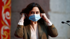 Isabel Díaz Ayuso se coloca la mascarilla tras su intervención durante un homenaje del Gobierno regional a los docentes madrileños en la Puerta del Sol, en Madrid (España), a 29 de octubre de 2020. | EP