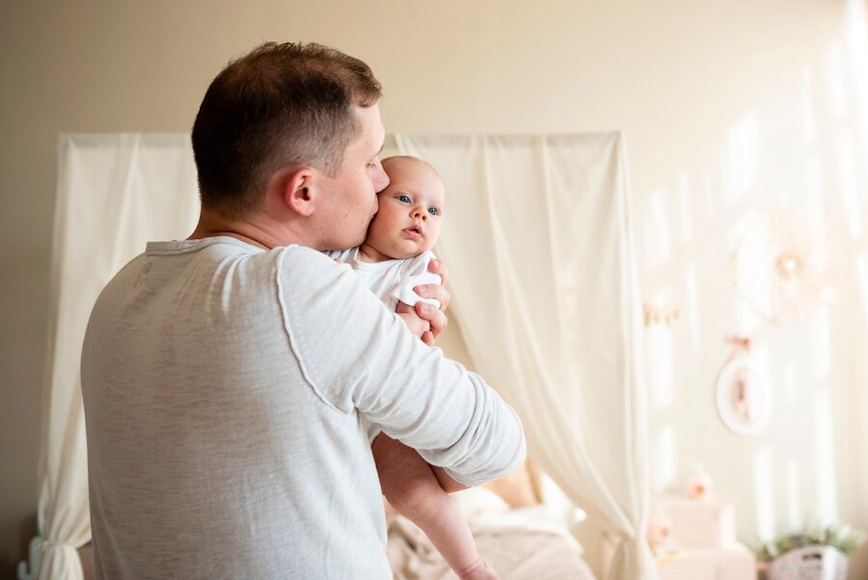 Un padre besa a su bebé