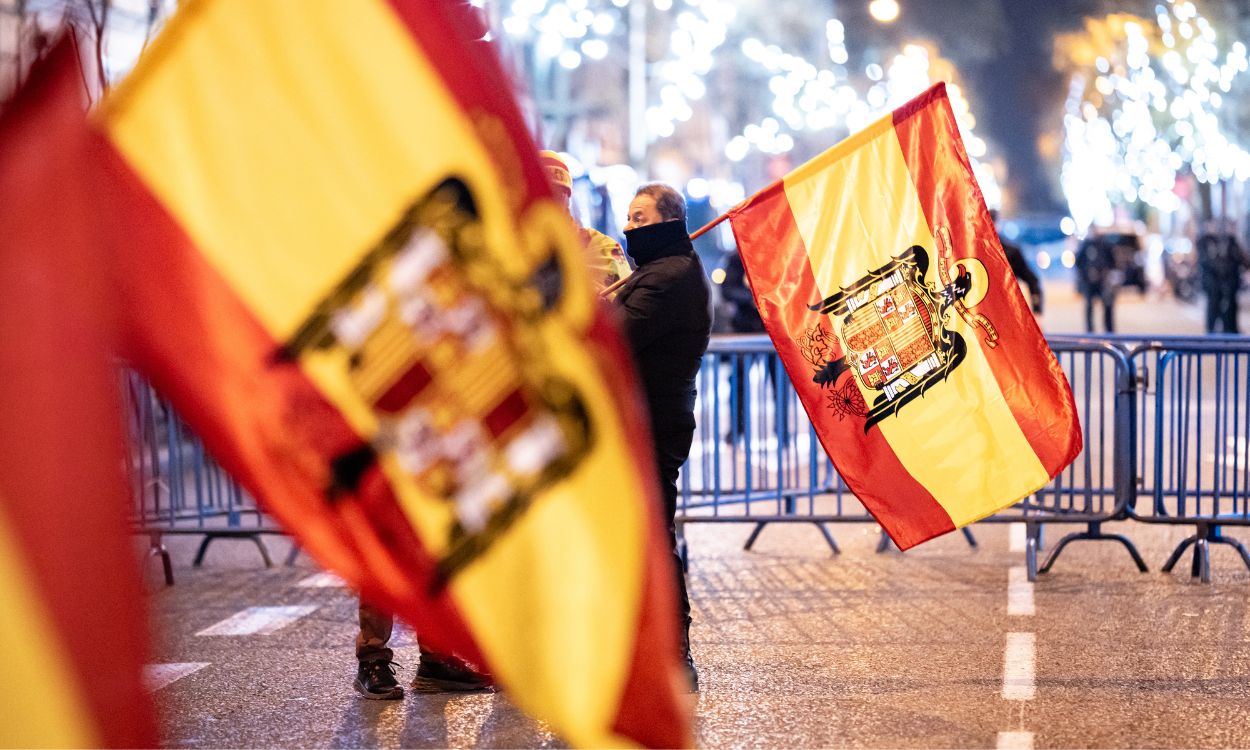 Varias personas con banderas españolas preconstitucionales celebra la entrada del año nuevo, en la calle Ferraz, a 1 de enero de 2024, en Madrid (España). EP