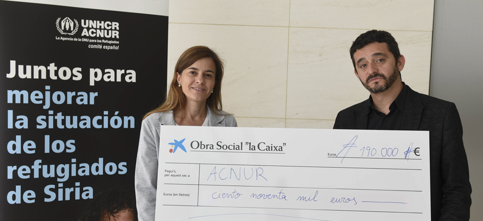 Ariadna Bardolet, subdirectora Área Internacional de la Obra Social 'la Caixa', entrega el cheque a Joan Reventós, de ACNUR