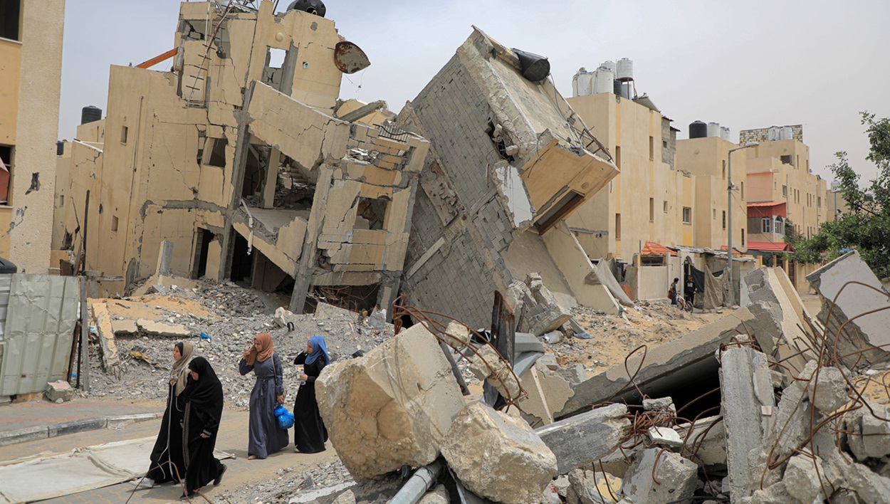 Personas caminando sobre las ruinas de la ciudad de Rafah. EP.