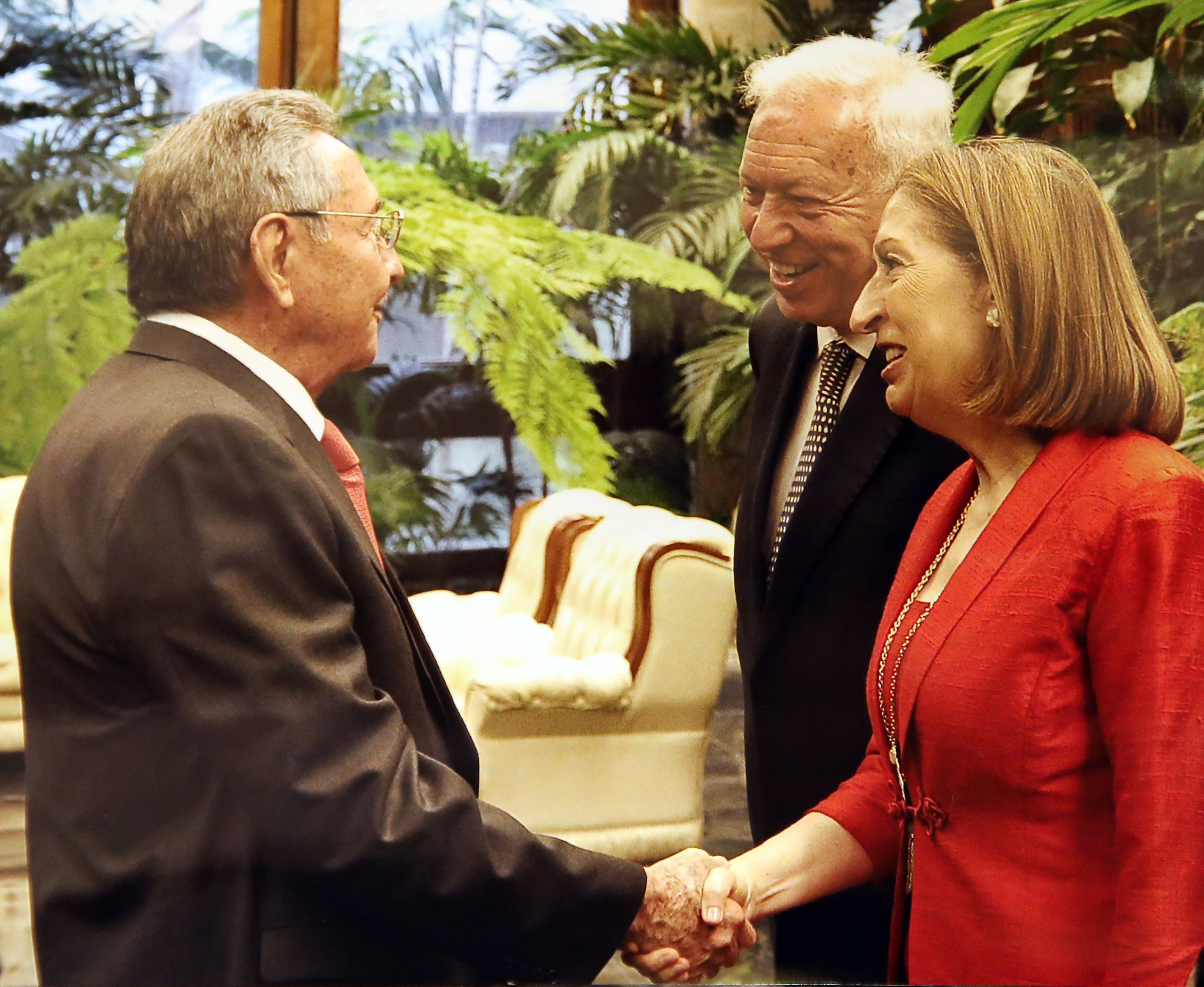 Reproducción de una fotografía impresa tomada por Estudios Revolución del presidente de Cuba Raúl Castro (i) quien saluda al ministro español de Asuntos Exteriores funciones, José Manuel García-Margallo (c) y a la ministra española de Fomento en funciones