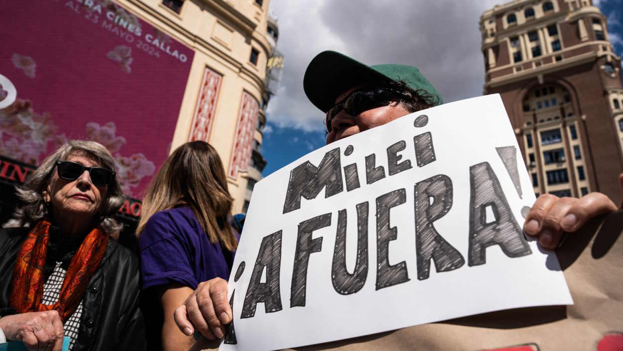 Una persona sostiene un cartel con la frase 'Milei afuera' durante la manifestación contra la visita del presidente argentino este sábado. EP