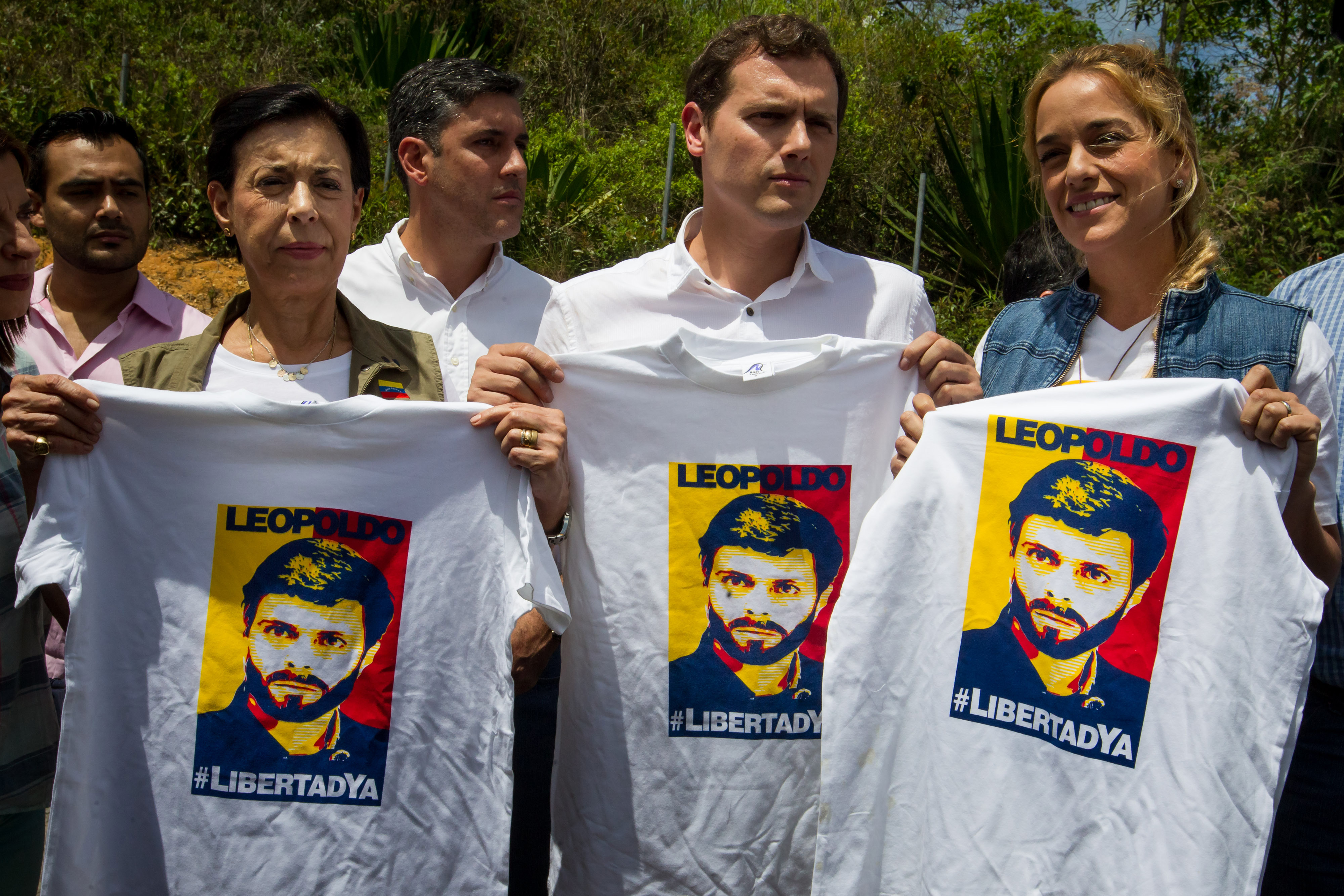 El líder del partido español Ciudadanos (liberal), Albert Rivera (c), posa sosteniendo camisetas con la imagen del dirigente opositor venezolano Leopoldo López acompañado por la madre de Leopoldo López, María Antonieta de López (2-i), y la esposa de Leopo