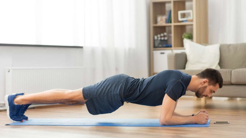 Un hombre realiza una plancha en su casa Un hombre realiza una plancha en su casa