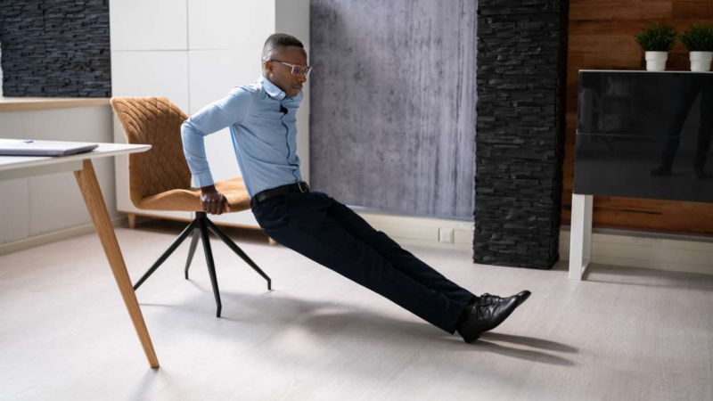 Un hombre hace dips en silla Un hombre hace dips en silla