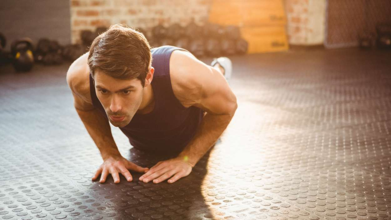 Un joven deportista realiza unas flexiones de tríceps Un joven deportista realiza unas flexiones de tríceps