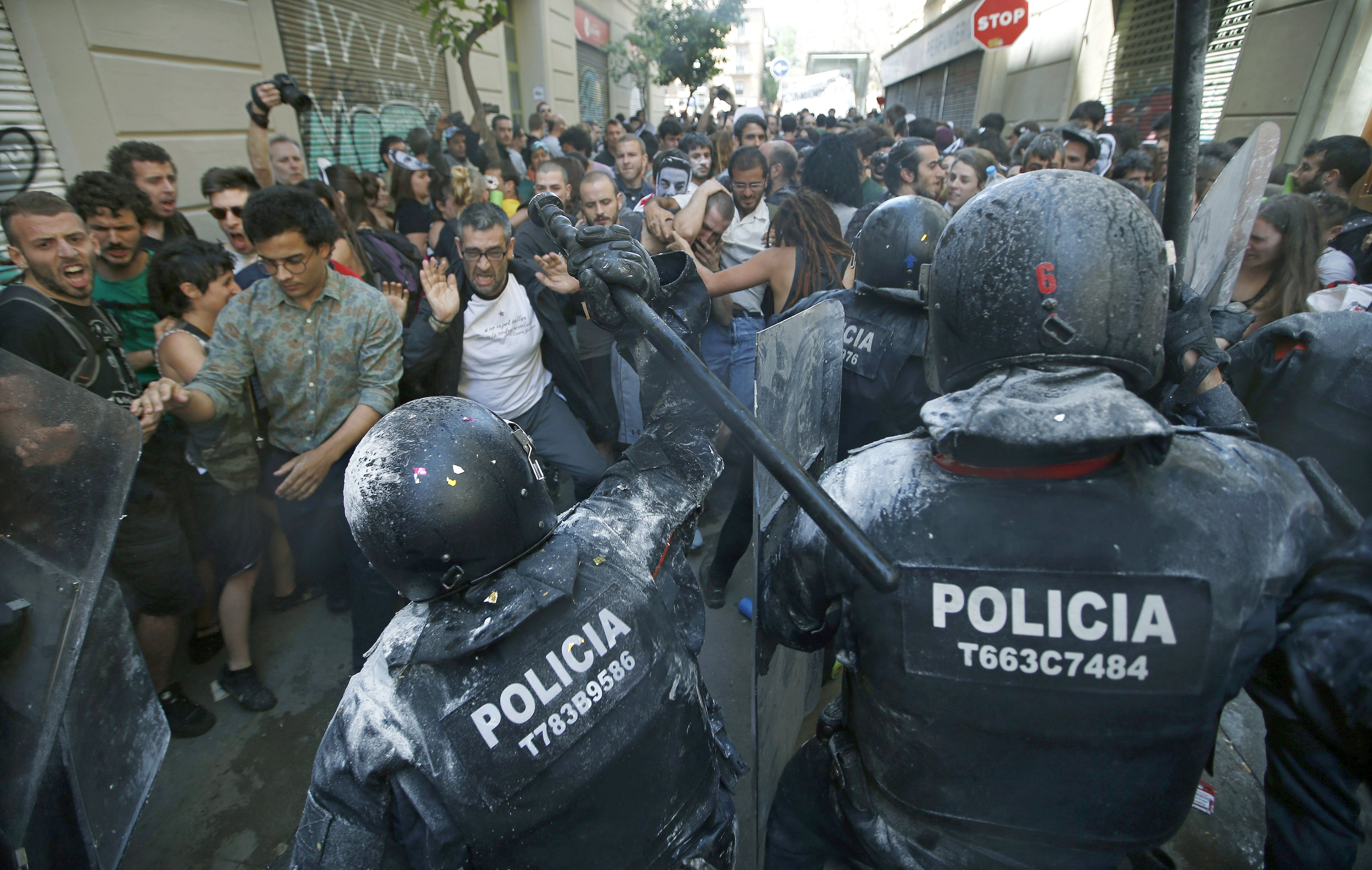 Manifestantes y antidisturbios de los Mossos d'Esquadra, durante los incidentes producidos ayer en el barrio de Gràcia de Barcelona.