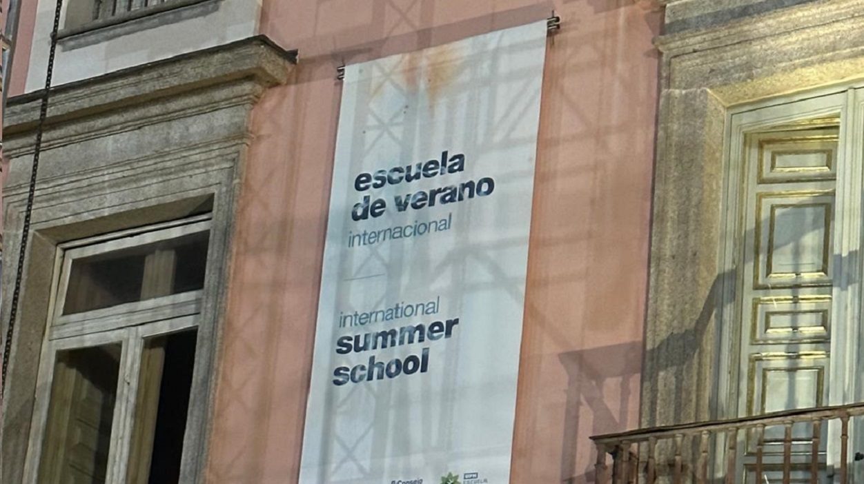 Fachada del palacio del infante don Luis, taladrada con el cartel de la Escuela de Verano.
