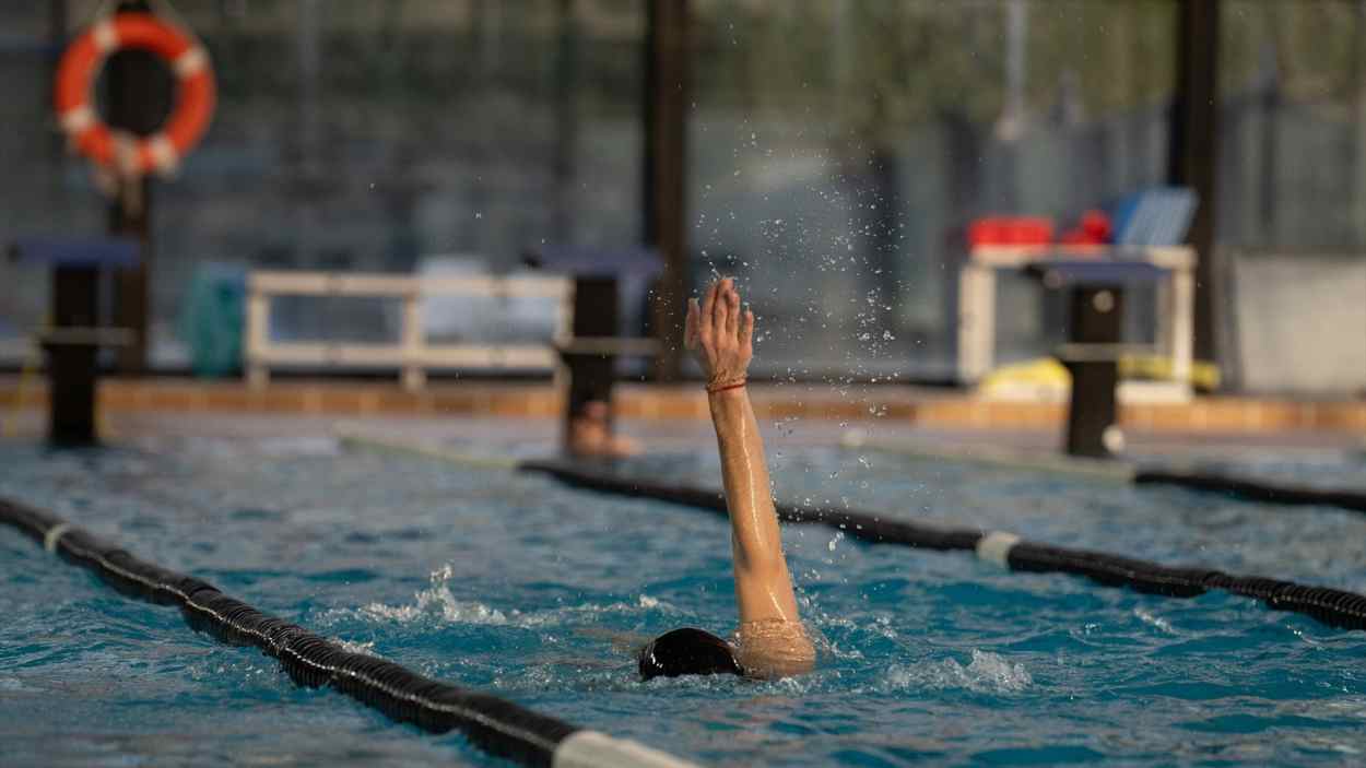 Una persona nada en una piscina. Imagen de archivo.