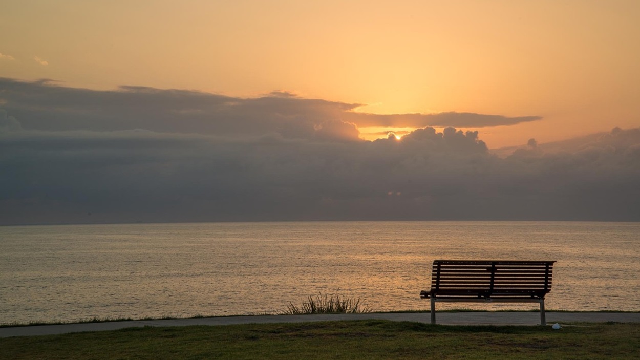 Imagen de recurso de un banco frente a la playa. Pixabay.