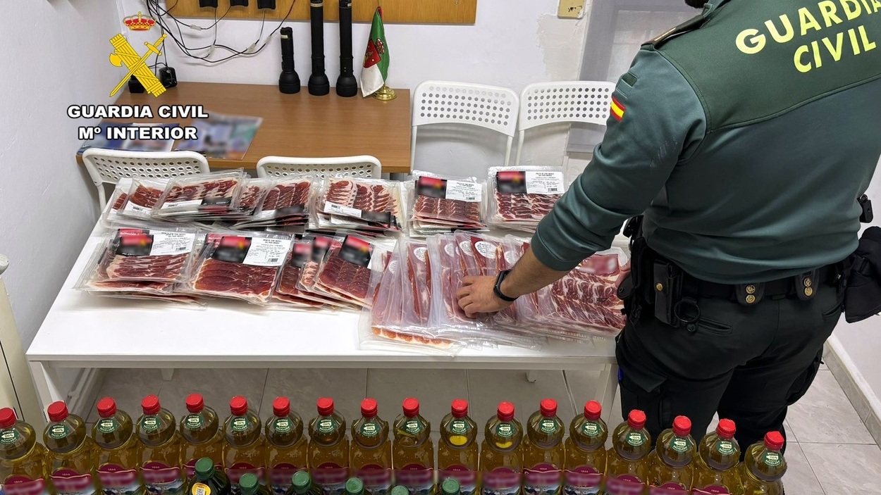 Agente de la Guardia Civil con el aceite y el jamón intervenidos. EP