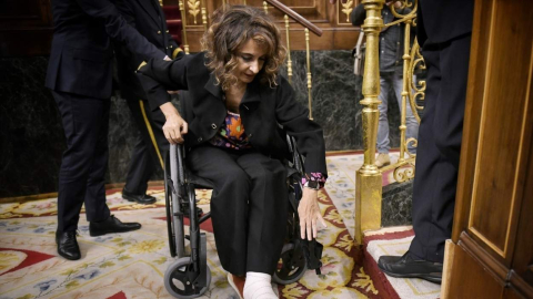 La vicepresidenta primera y ministra de Hacienda, María Jesús Montero, llega en silla de ruedas a una sesión de control al Gobierno, en el Congreso de los Diputados