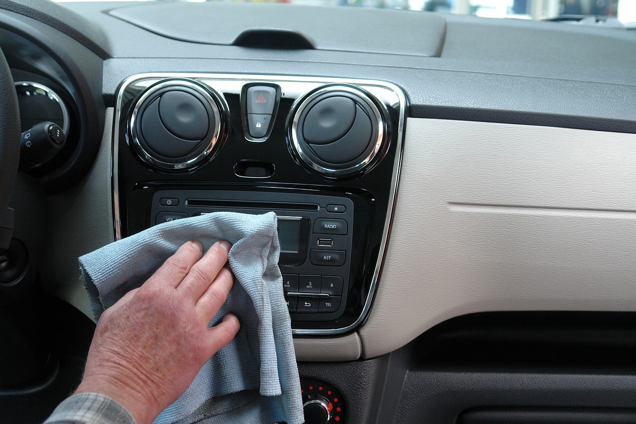 Un hombre limpia el interior de su coche con una balleta / PEXELS