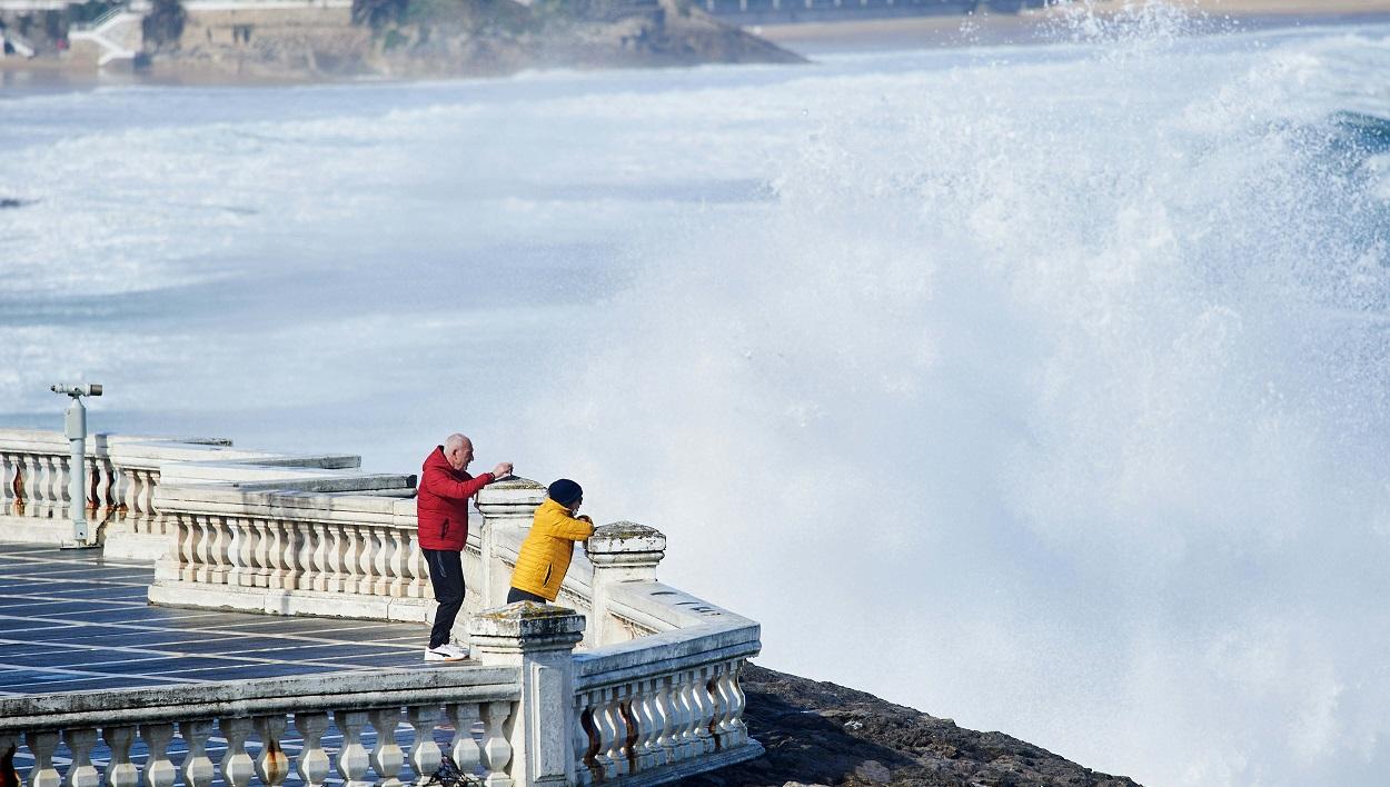 Personas ante el fuerte oleaje en el paseo marítimo de Santander. EP