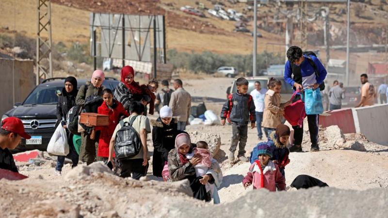 Refugiados pasando por encima de un agujero provocado por un ataque israelí en el Líbano. EP.