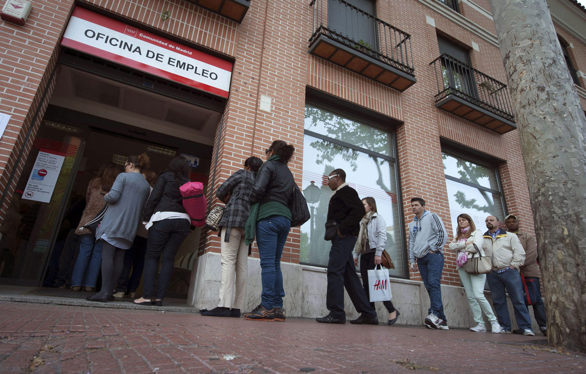 Un grupo de personas hacen cola en una oficina del INEM en Alcalá de Henares (Madrid)