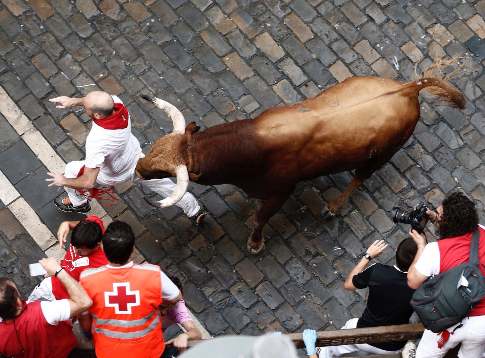 Un mozo corre ante los toros de Pedraza de Yeltes que han protagonizado esta mañana un encierro rápido, marcado por la presencia masiva de mozos en el único domingo de estos sanfermines. 