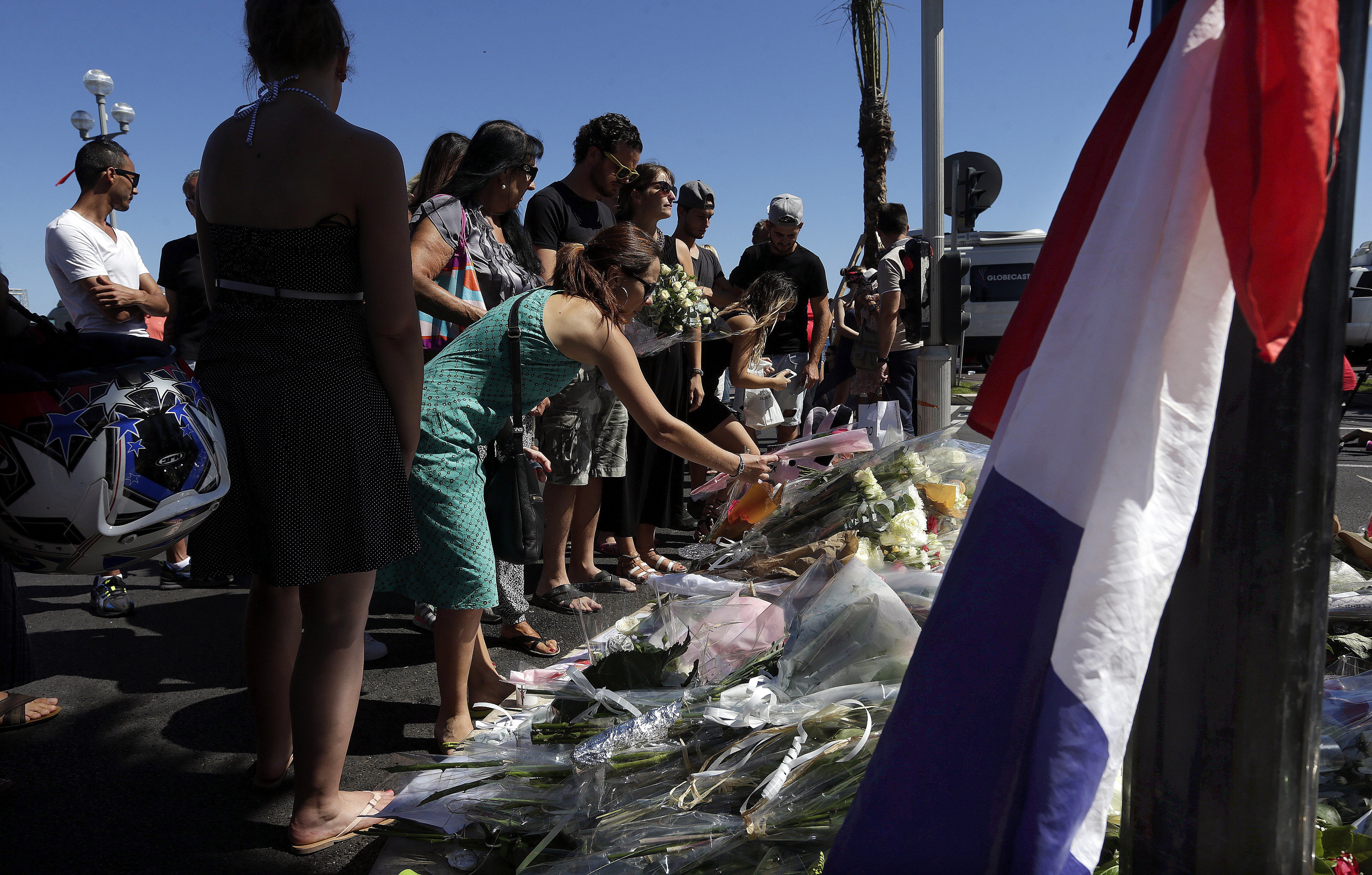 Numerosas personas depositan flores, muñecos de peluche y mensajes de condolencia en las inmediaciones del paseo marítimo de Niza.