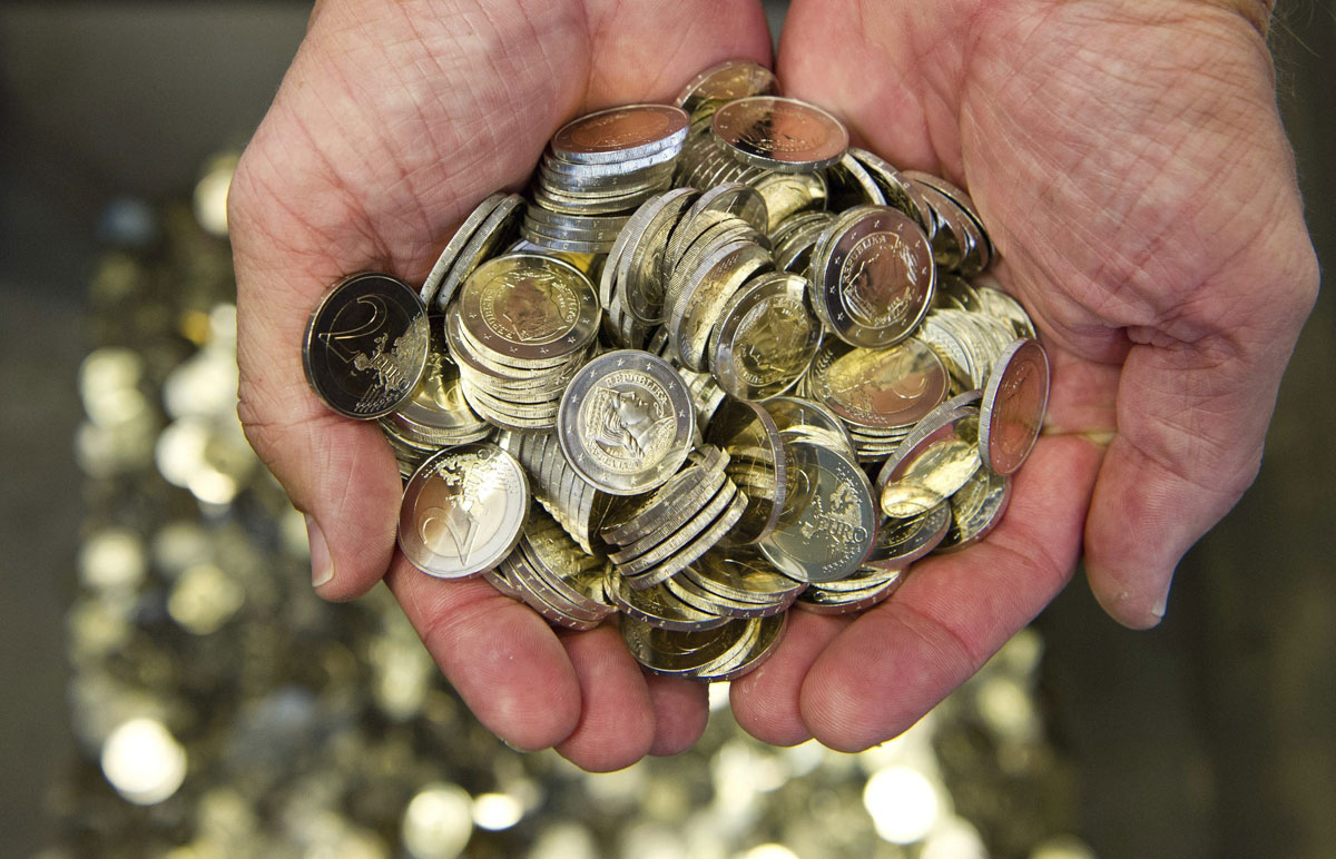 Un hombre sostiene varias monedas de euro