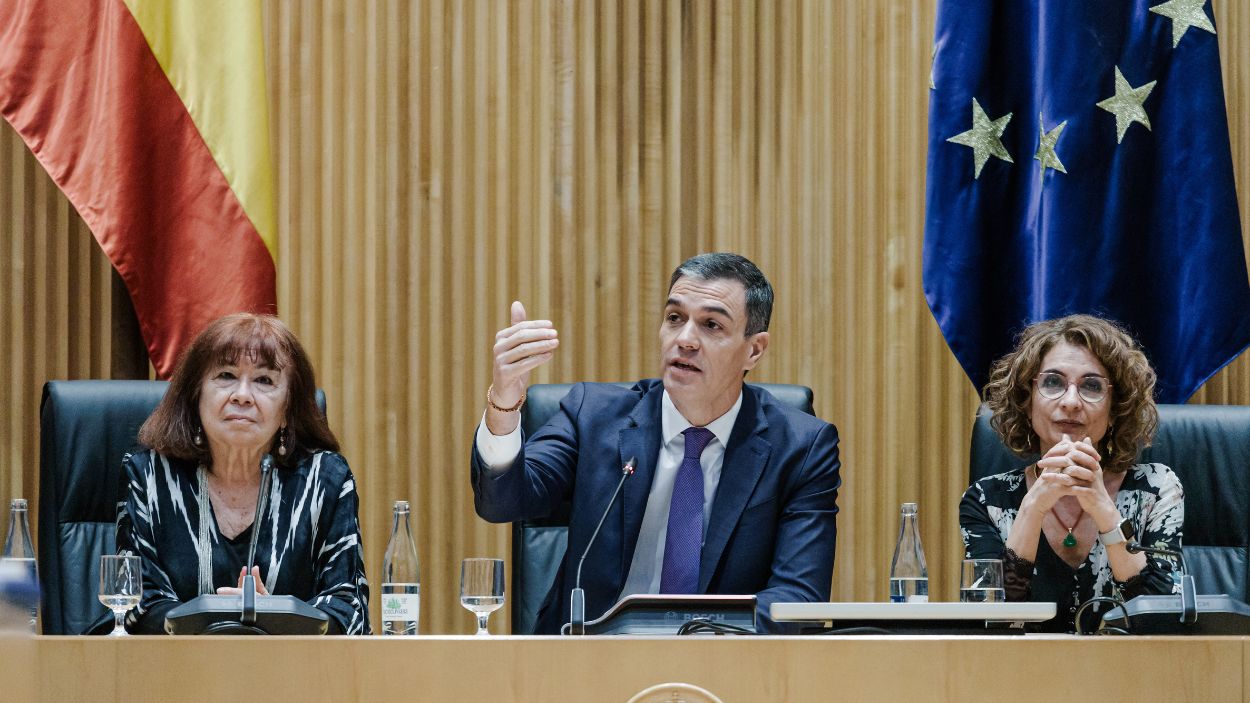 El presidente del Gobierno, Pedro Sánchez, flanqueado por la presidenta del PSOE, Cristina Narbona, y la vicepresidenta primera, María Jesús Montero, en la interparlamentaria del Grupo Socialista.