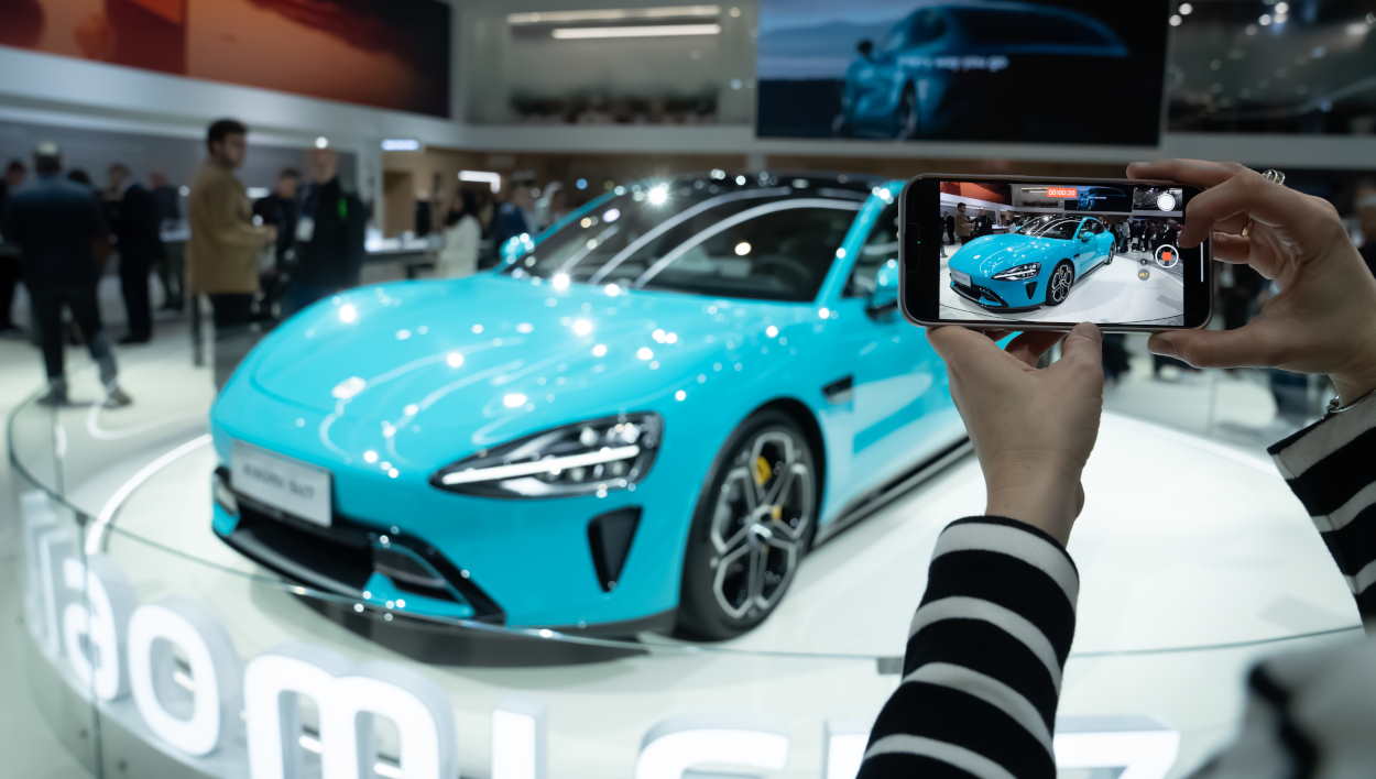 Una persona con un móvil en la presentación del coche Xiaomi SU7 en la edición 2024 del MWC. EP