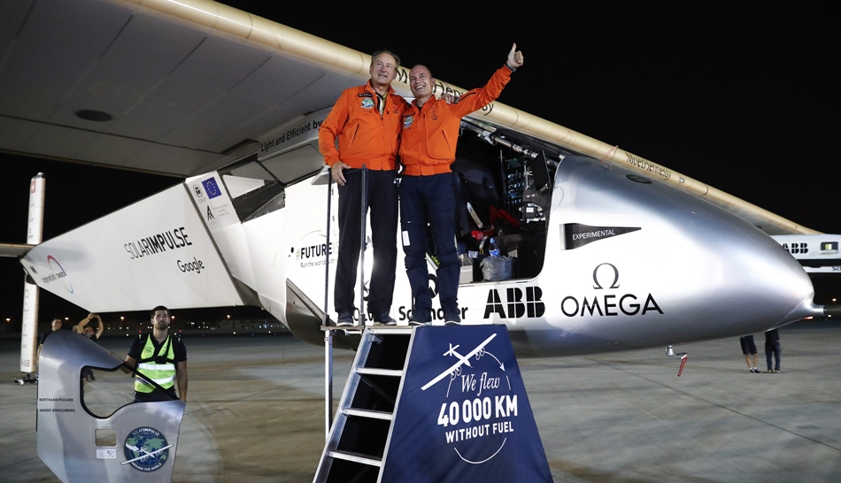 Bertrand Piccard y André Borschberg saluda en el aeropuerto de Abu Dabi ante el Solar Impulse II.