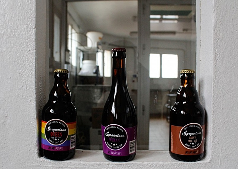 Imagen de las tres cervezas artesanales de la marca con la especial para mujeres en medio. 