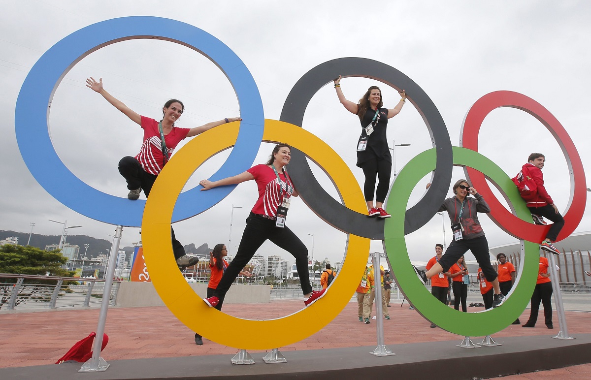 Varias personas posan junto a los anillos de los Juegos Olimpicos