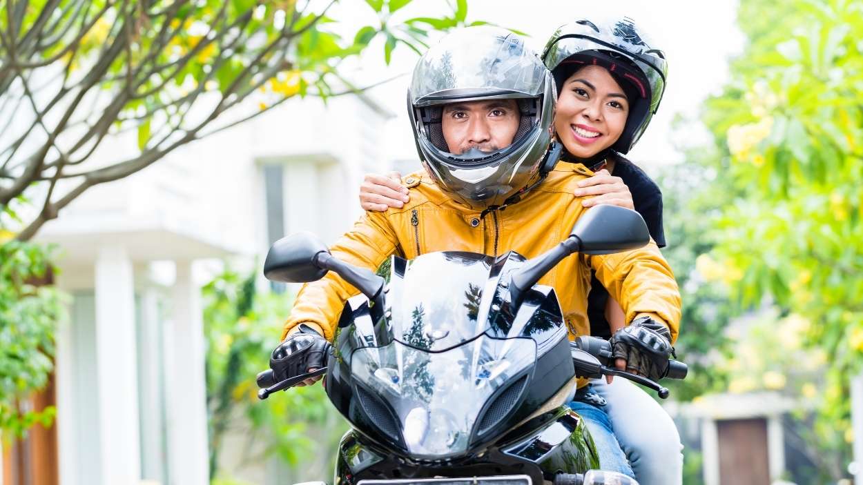 Una mujer y un hombre en una moto. Canva