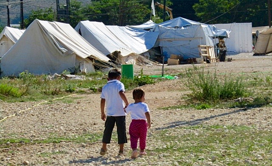 Dos niños caminan hacia las tiendas de campaña de un campo de refugiados