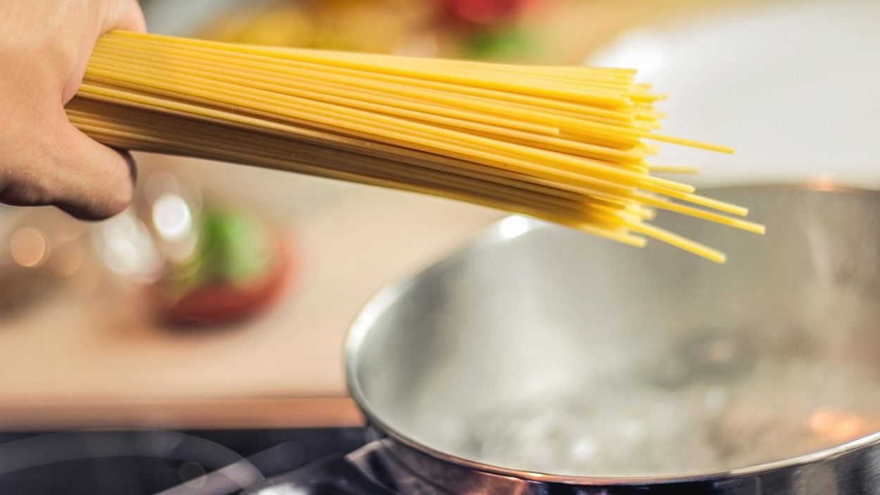 Un puñado de pasta sobre una olla de agua hirviendo. Pixabay