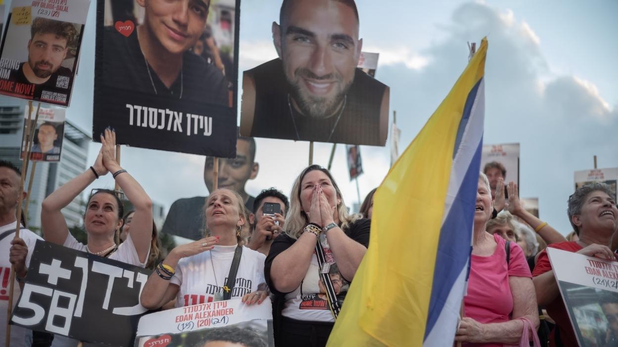 Israelíes en la Plaza de los Rehenes que buscan seguir a Edan Alexander tras su liberación. EP