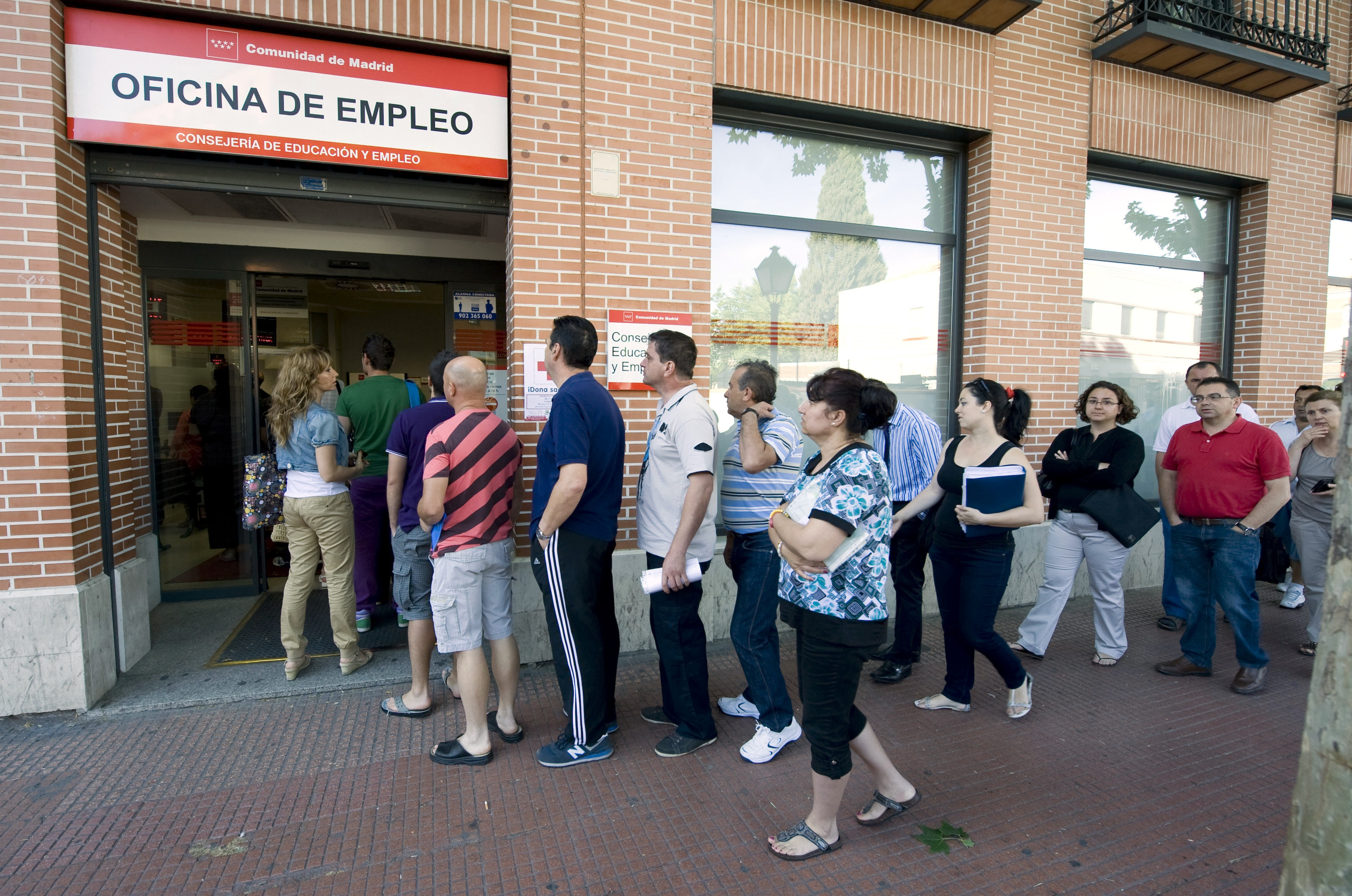 Un grupo de personas hace cola en una Oficina de Empleo en Alcalá de Henares (Madrid)
