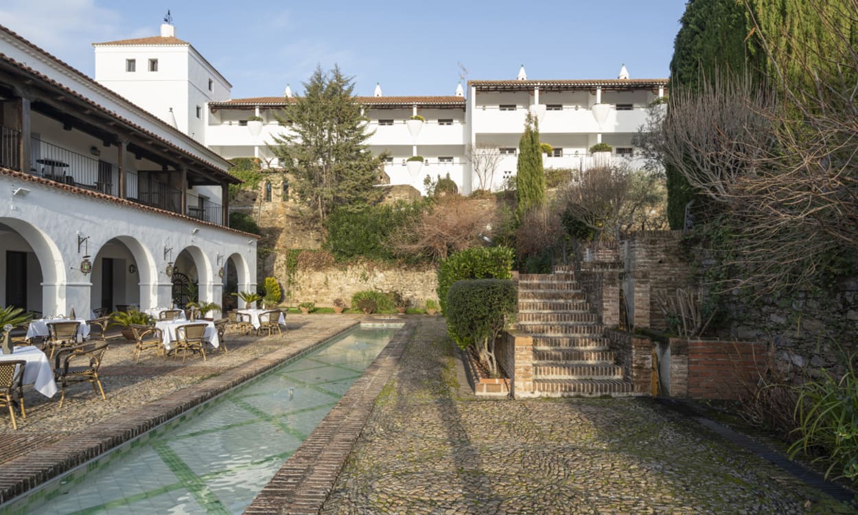 El jardín trasero, con su estanque y suelos tradicionales, evoca el esplendor mudéjar del edificio