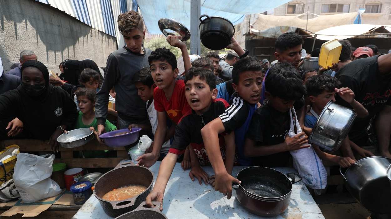 Palestinos esperan en colas para la distribución de comida en Nusairat. EP