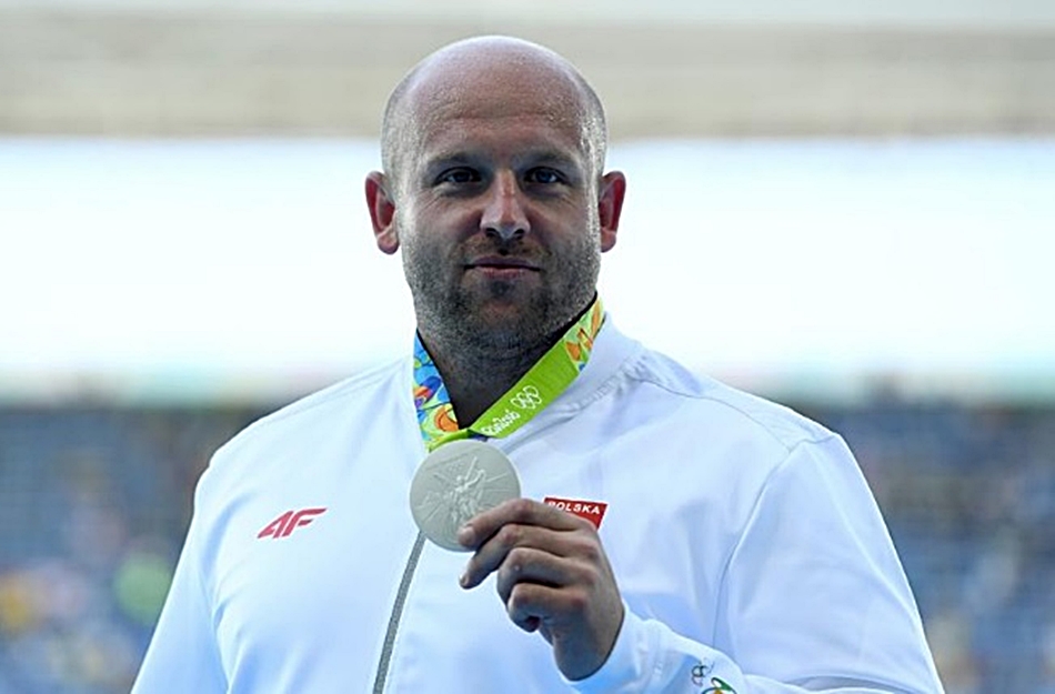 Piotr Malachowski en el podio de Río con la medalla de plata que ahora será subastada. 