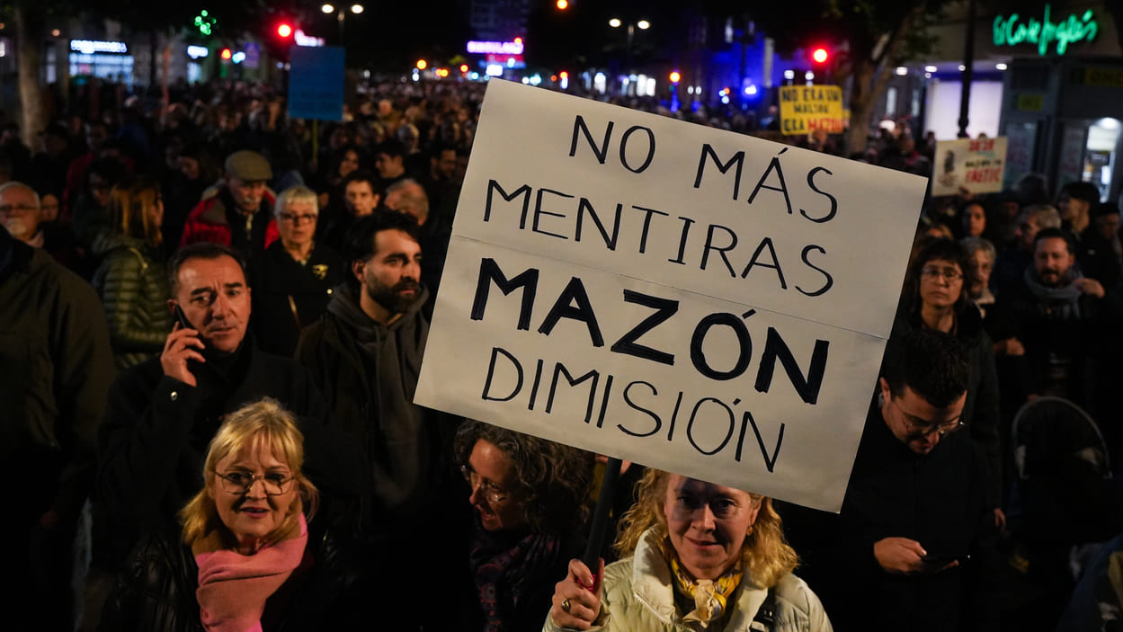 Una mujer sostiene una pancarta durante una manifestación para exigir la dimisión de Mazón. EP.