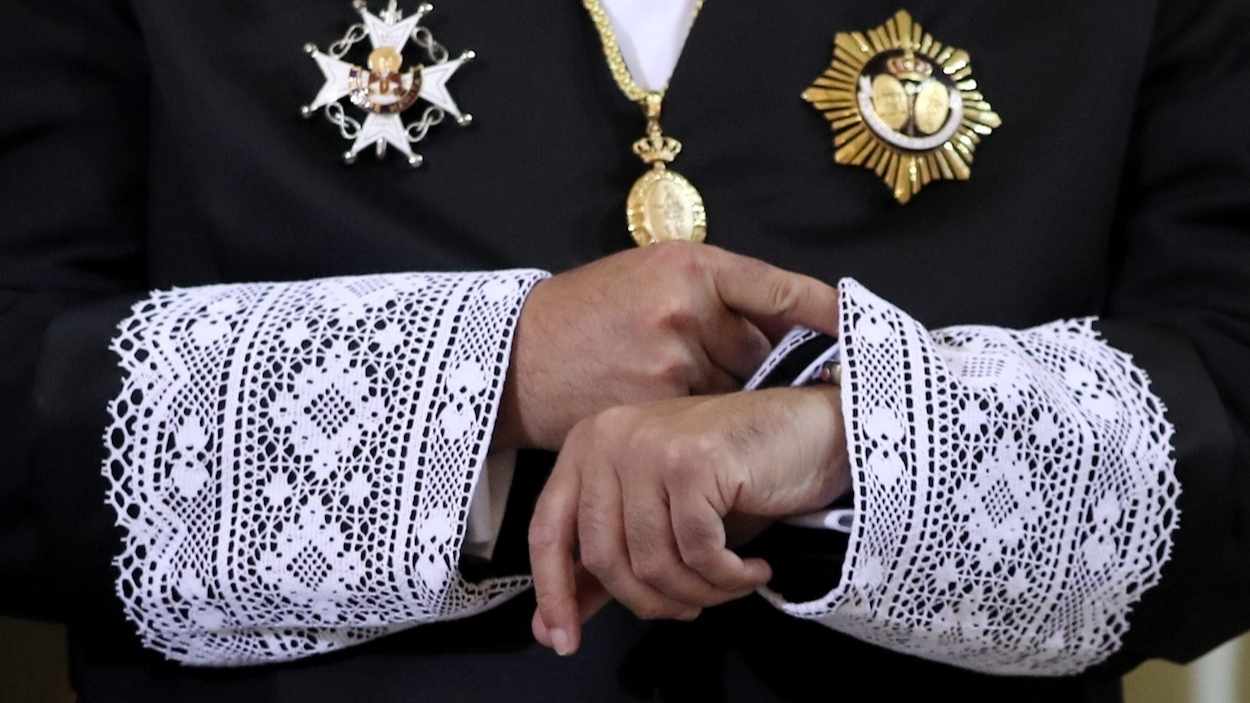 Un juez mira la hora de su reloj, vestido con la toga negra que visten en las vistas orales. EP