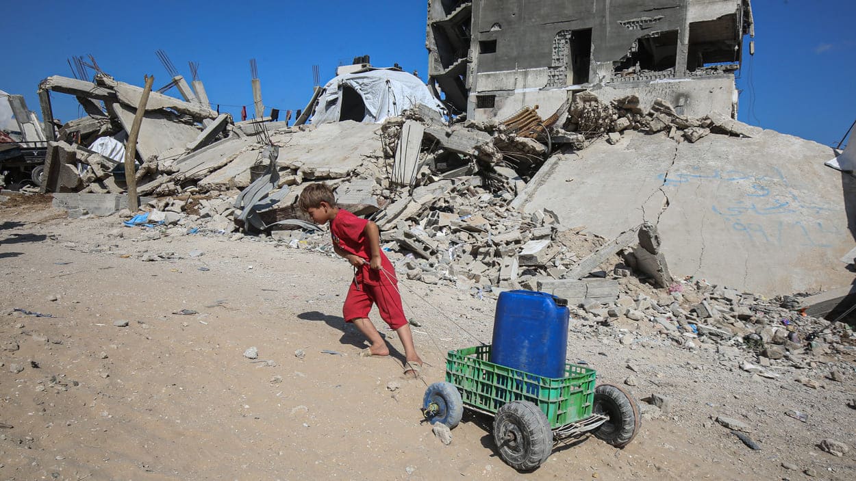 Un niño palestino arrastra una garrafa de agua en Gaza. EP