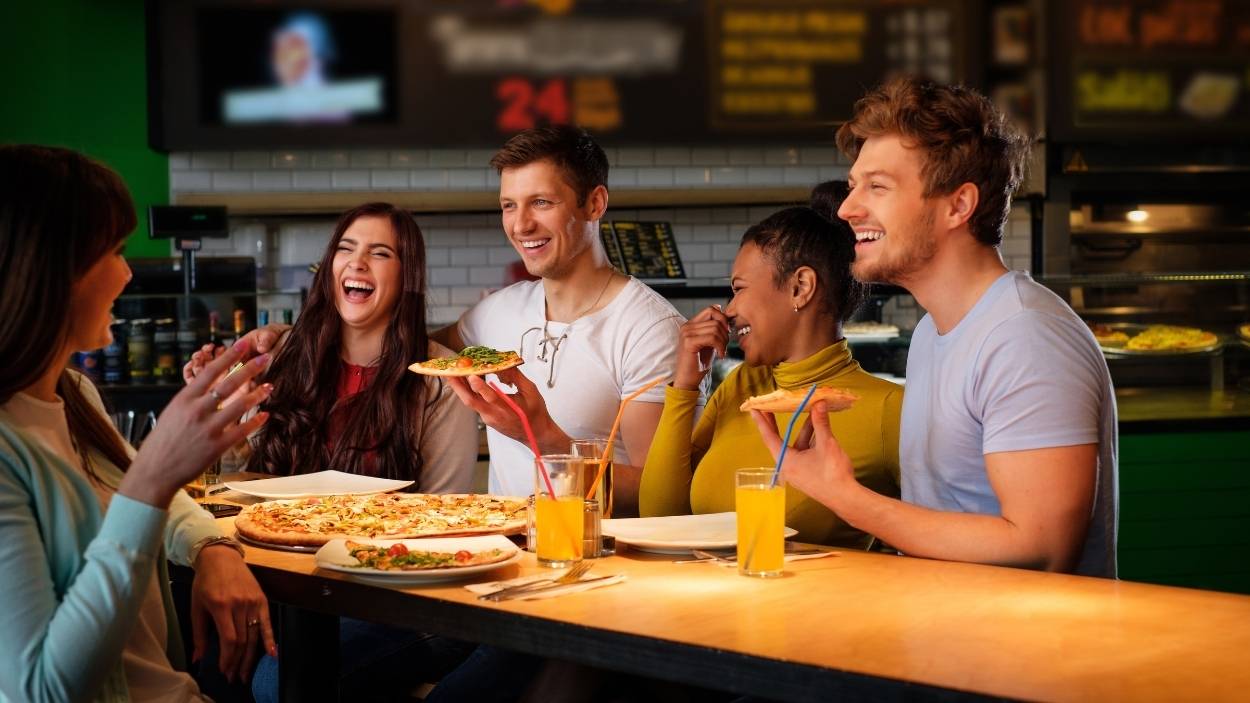 Un grupo de personas en una pizzería. Canva