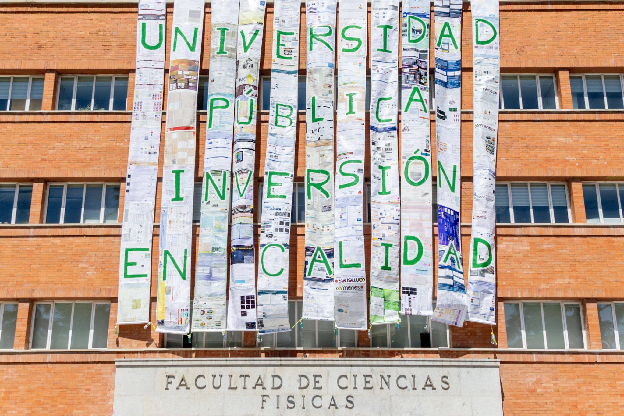 Un mural cuelga de la fachada de la Facultad de Físicas de la UCM. EP.