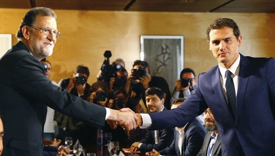 Momento en que, a petición de los medios, Rajoy y Rivera se han estrechado la mano. 