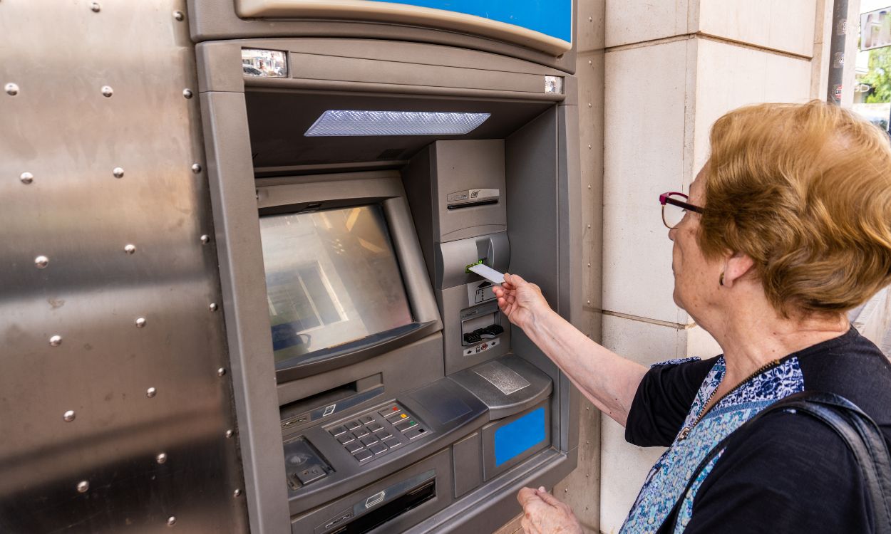 Una mujer mayor usando un cajero automático