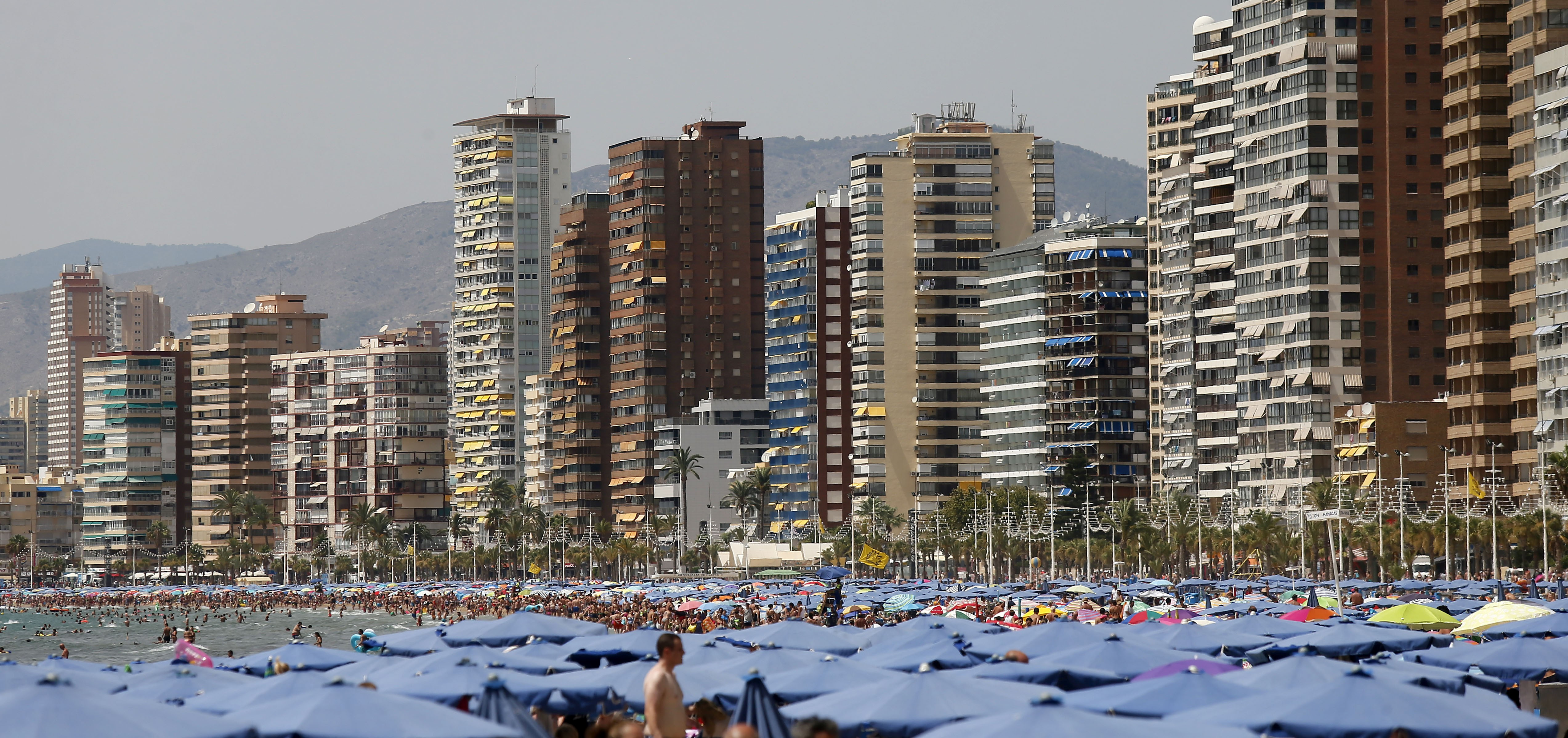 Miles de turistas disfrutan del sol y las altas temperaturas en la playa de Levante de Benidorm.