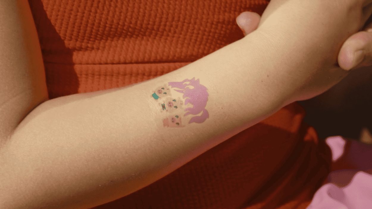 Este tatuaje temporal impreso con tintas fotosensibles cambia al exponerse al sol y hace aparecer la figura del lobo. Servimedia.