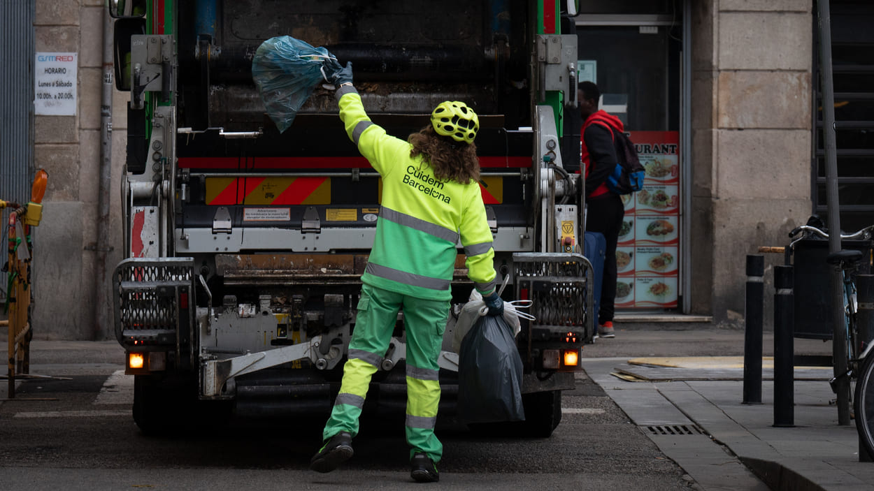 Una persona del servicio municipal de limpieza recoge basura, en el barrio del Raval. EP.