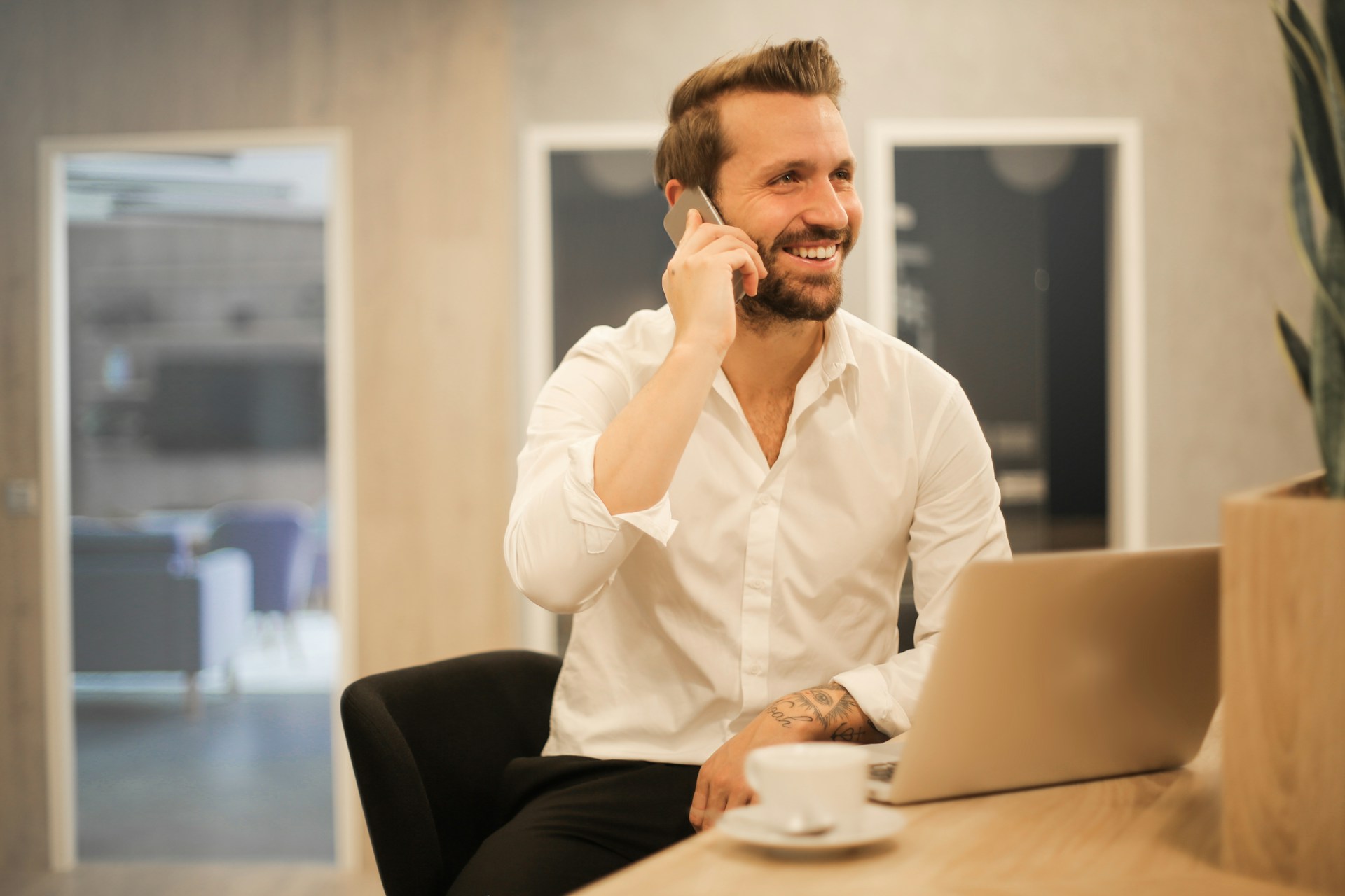 Empresario sonríe mientras atiende el teléfono / Foto de Bruce Mars / UNSPLASH